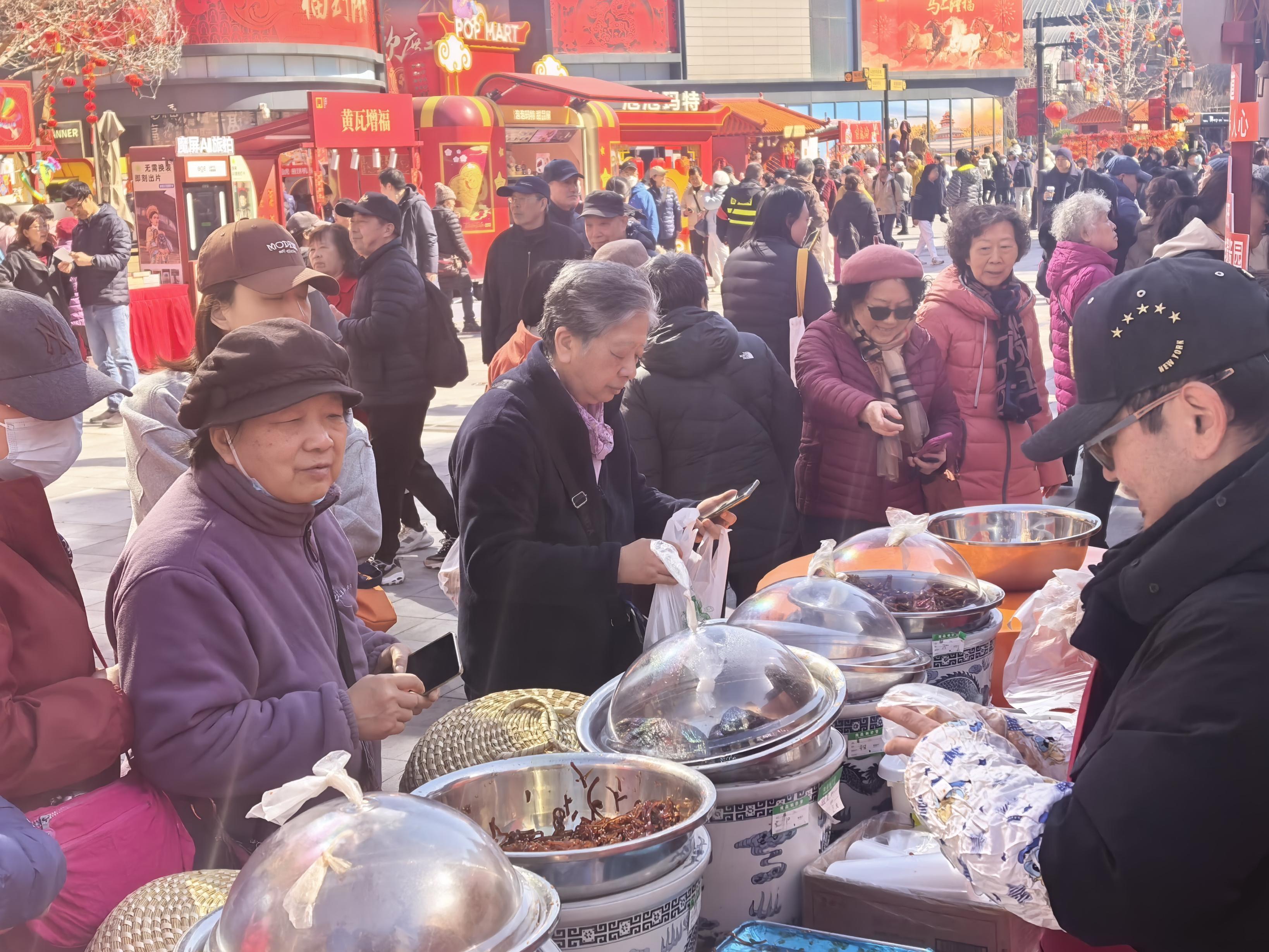 老居民在隆福寺市集选购老字号六必居酱菜。 老居民在隆福寺市集选购老字号六必居酱菜。