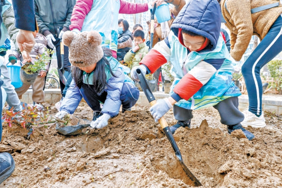 朝阳区茉藜园社区的小朋友参加绿地大扫除。