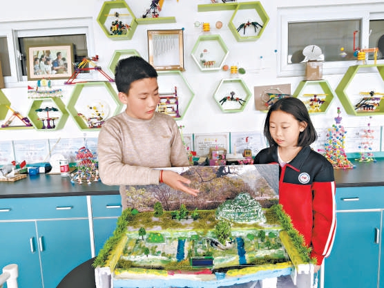 两位同学介绍自主研发的山地智能分层灌溉系统。