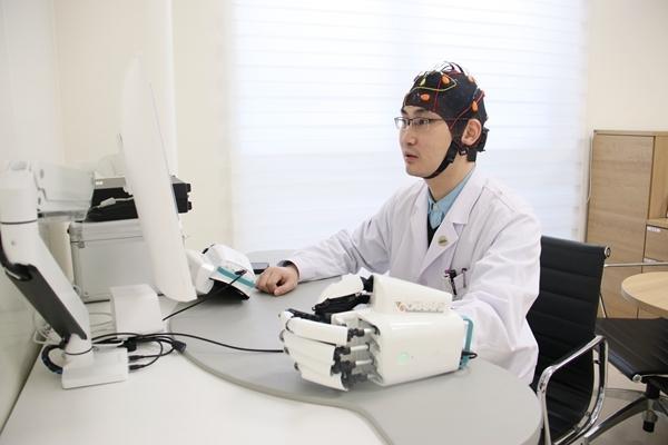 北京协和医院神经外科主治医师常健博正在诊室里调试非侵入式脑机接口设备。 北京协和医院神经外科主治医师常健博正在诊室里调试非侵入式脑机接口设备。