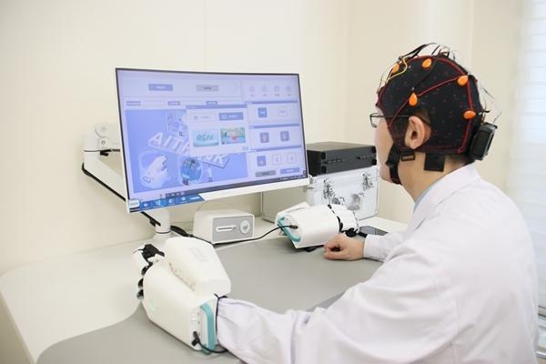 北京协和医院,常健博医生头戴脑电帽,演示非侵入式脑机接口的治疗过程。 北京协和医院,常健博医生头戴脑电帽,演示非侵入式脑机接口的治疗过程。