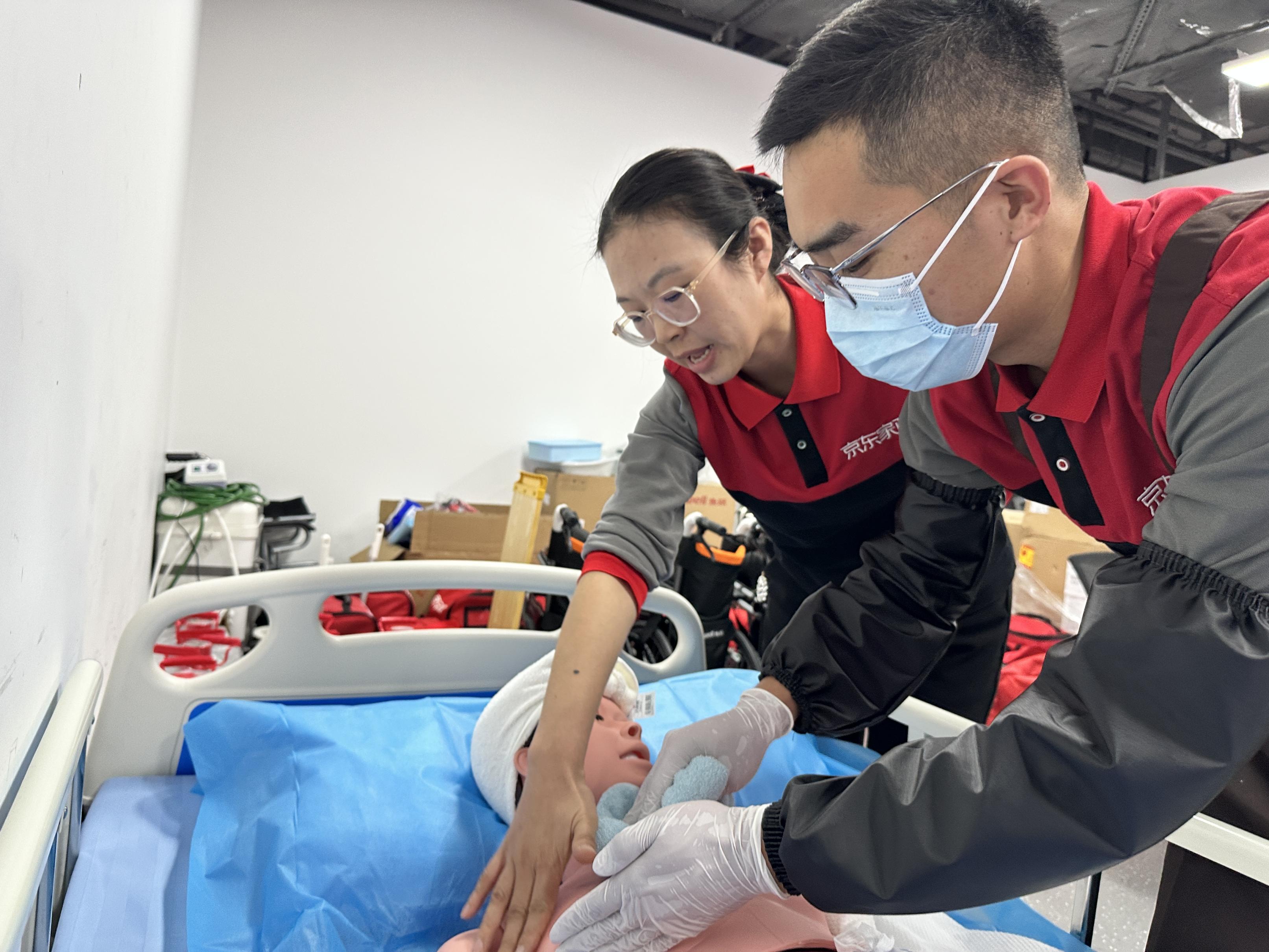 张敏（左）指导家政学员学习养老助浴技能