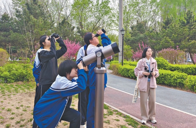 北京市第十二中学学生在公园里开展科普活动。