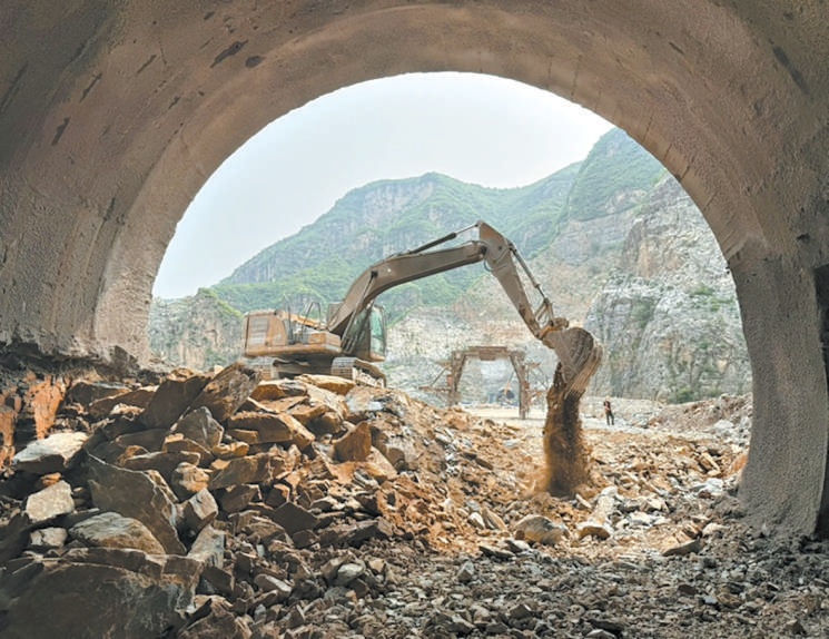 农场隧道贯通施工现场,挖掘机正清理洞口碎石。 农场隧道贯通施工现场,挖掘机正清理洞口碎石。