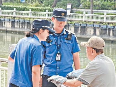 城管执法队员对骑车人进行劝导。 城管执法队员对骑车人进行劝导。