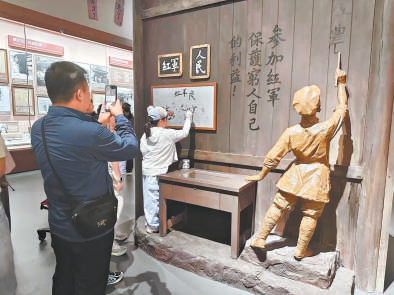 小观众在展厅互动场景中写下“人民”“红军”。 小观众在展厅互动场景中写下“人民”“红军”。