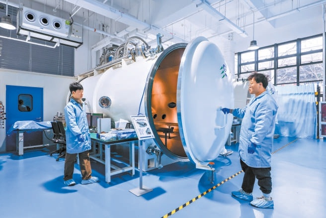 在金隅智造工场商业航天企业易动宇航生产车间，研发人员在真空模拟舱前进行点火测试。