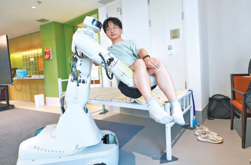 护理机器人将一名成年男子从床上抱起。