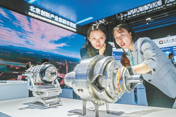 在2023中关村论坛展览（科博会）北京创新产业集群示范区展区，参观者驻足观看一台自主研发的波转子航空发动机。