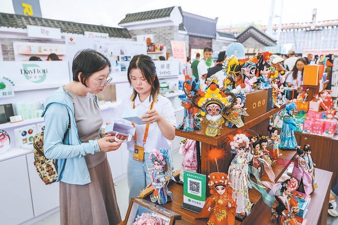 在2025年服贸会北京礼物展区，观众在京味商业街区选购北京特色文创产品。