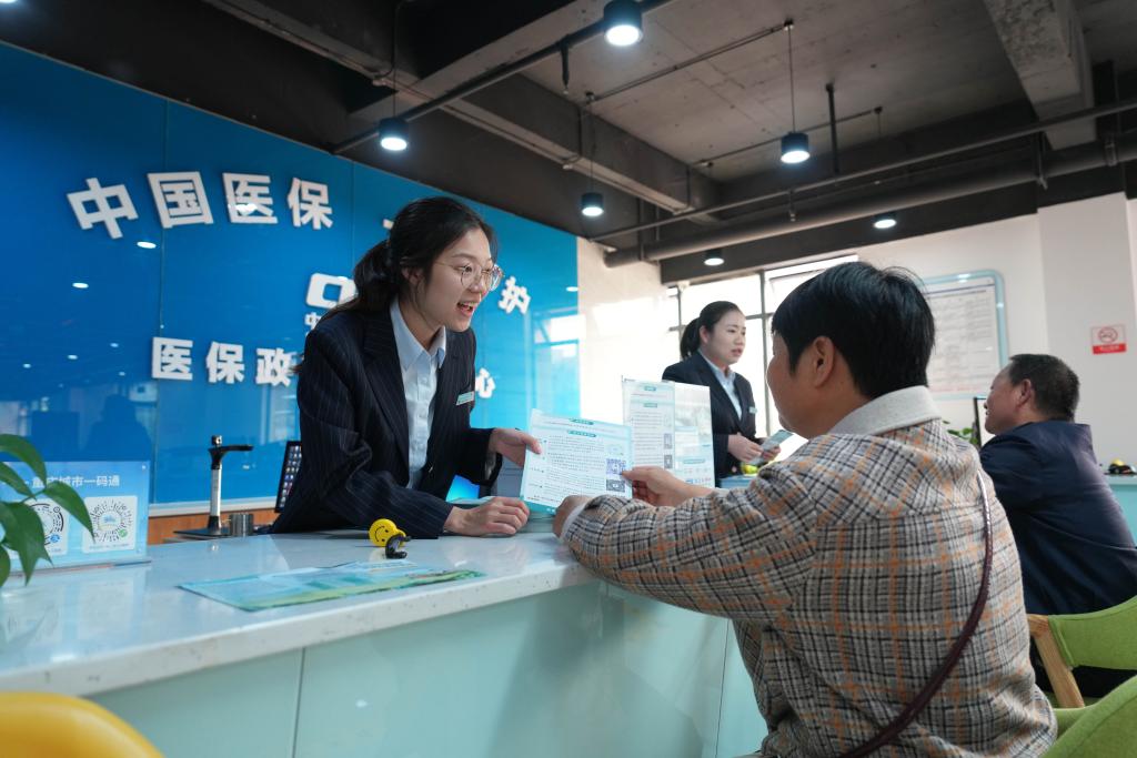 2023年11月1日，在重庆市北碚区歇马街道医保政务服务分中心，工作人员给居民讲解医保政策。