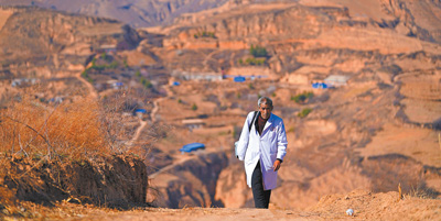 張尚保走在去鐵頭村張家灣自然村出診的路上。