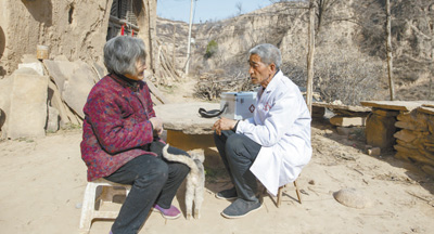 張尚保(右)正在為村民講解健康知識。