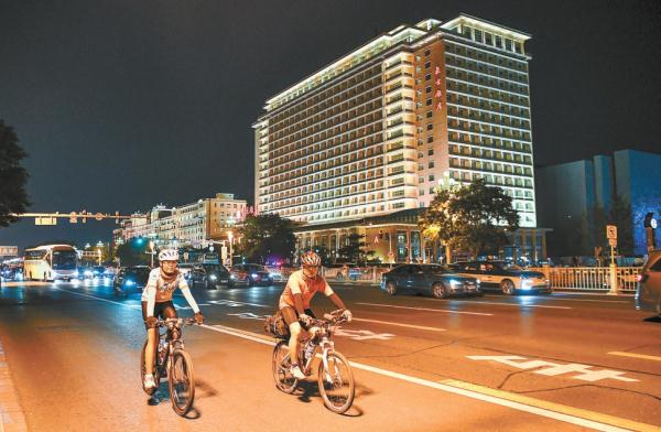 入夜後，騎行愛好者在東長安街王府井路段騎行。