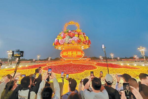 9月25日傍晚，天安門廣場“祝福祖國”巨型花籃亮起燈光，璀璨奪目，現場游客一片歡呼聲，爭相留影。