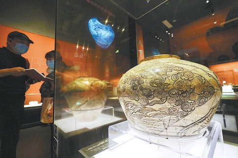 遊客駐足觀賞出土于北京元大都遺址的白地黑花龍鳳紋瓷罐。