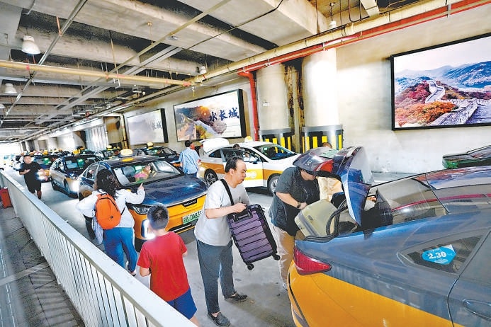 在北京南站北樞紐計程車調度站，乘客有序乘車。