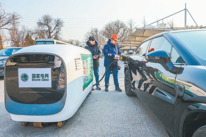 1月23日，在京藏高速公路百葛服務區電動汽車充電站，國網北京電力工作人員使用可遙控移動充電車為電動汽車充電。