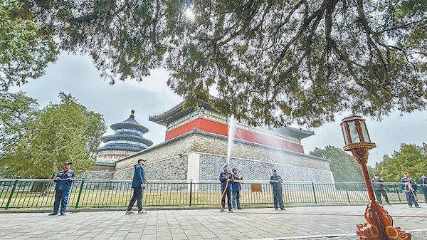 3月23日中午，天壇公園東門內，工作人員對古樹進行噴水作業。
