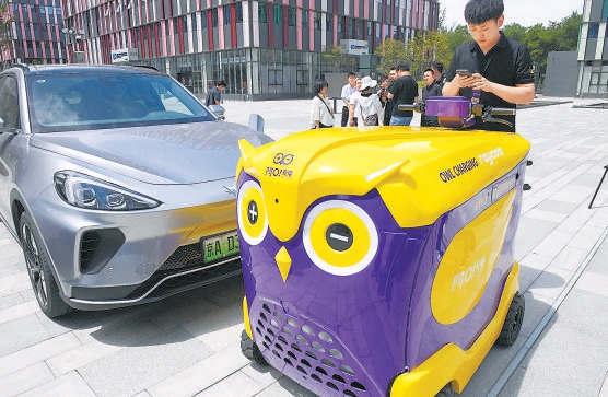 機器人“阿O”正為新能源汽車充電。