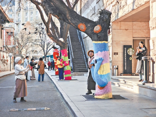 降雪前，東城區紅星衚同的大樹穿上“毛衣”，市民紛紛打卡。