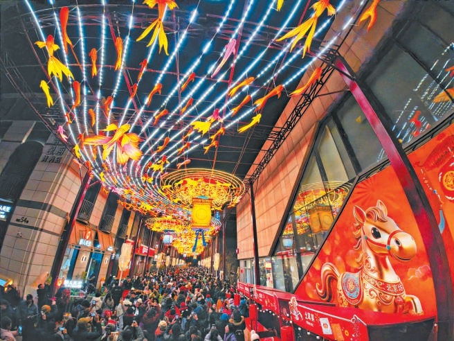 除夕夜，北京坊張燈結綵，年味濃郁。巨型彩繪馬年主題球高懸街巷，絢麗花燈如星河垂落。市民遊客賞燈漫步，在傳統非遺與新潮年味的交融中，感受京城新春的獨特魅力。