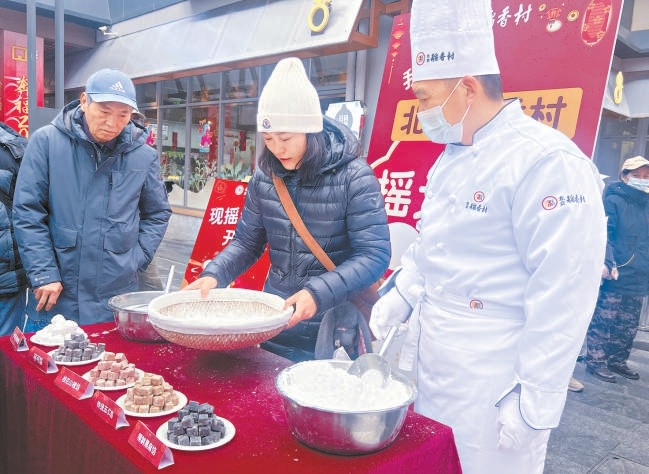 隆福寺新春市集的稻香村攤位前，市民在廚師指導下體驗搖元宵。
