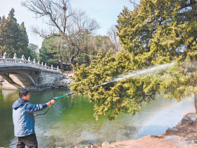 圖為工作人員用高壓水槍進行濕化作業。