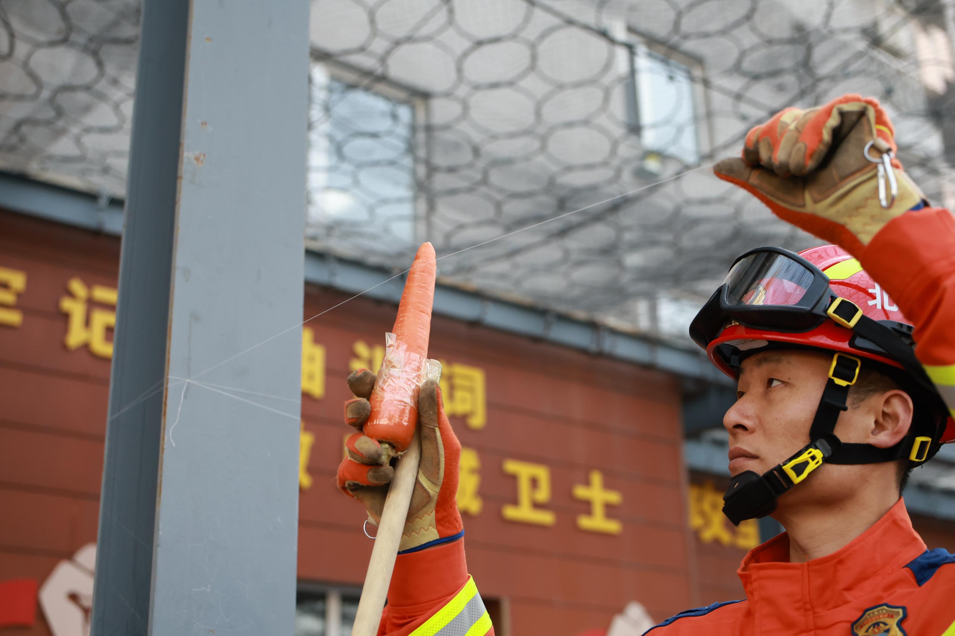 消防員手舉胡蘿蔔測試風箏線的鋒利程度。