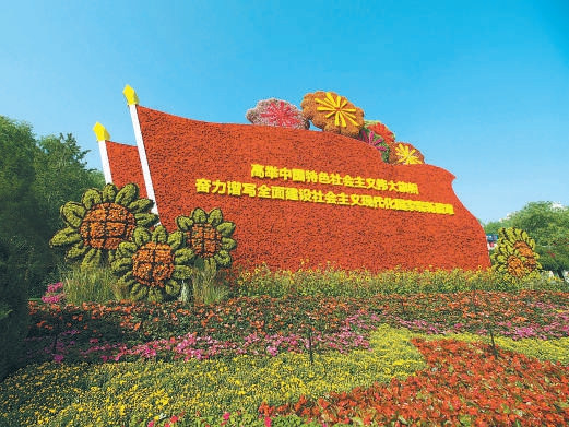 建國門西北角“偉大征程”花壇，花壇頂高8米，以嵌有文字的紅旗為主景，配以向日葵、煙花等，寓意奮進新征程，吹響全面建設社會主義現代化國家的時代號角。