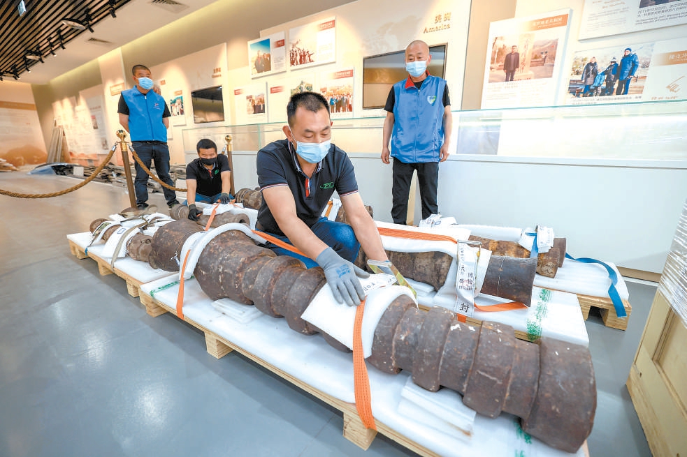 工作人員將大炮固定在托盤上，之後用液壓拖車統一運輸。