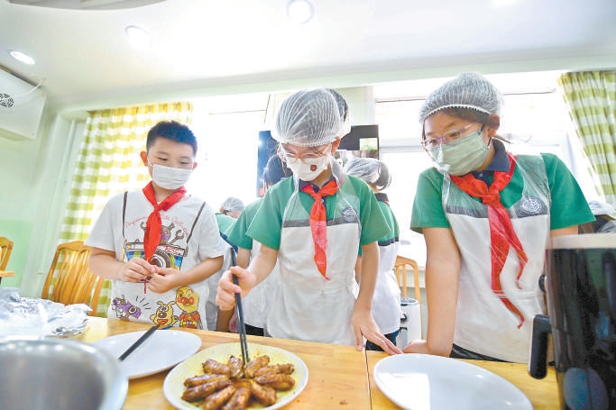 朝陽區芳草地國際學校世紀小學，孩子們在學校小花園裏翻地，在勞動課堂烤雞翅。