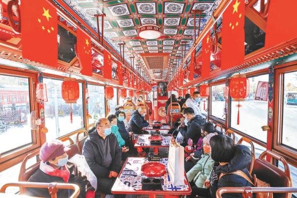 為迎接元宵節，倣古鐺鐺車內挂滿紅燈籠，車窗上還有燈謎，游客一邊猜燈謎一邊品嘗北京小吃，節日氣氛濃郁。