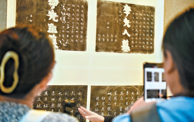 觀眾認真觀看李大釗烈士和夫人墓碑拓片。