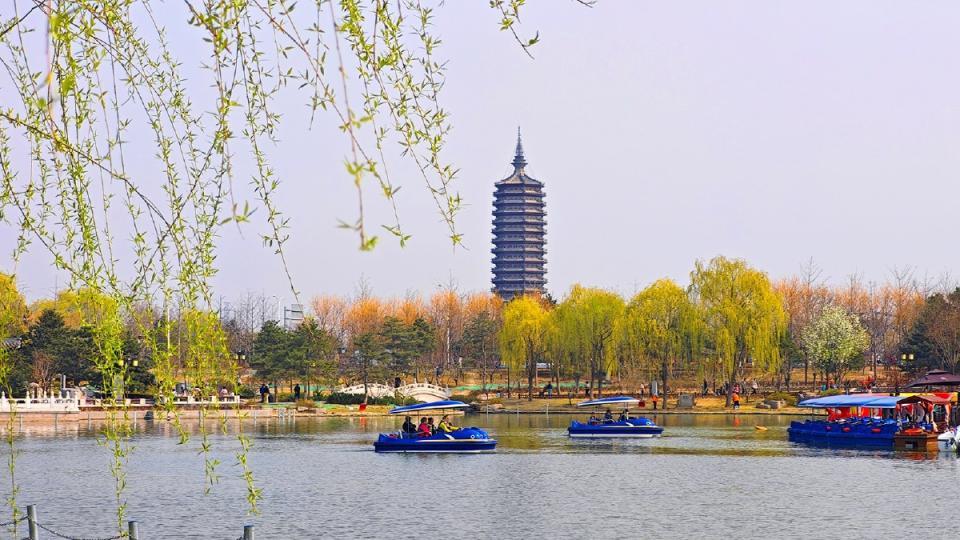 遊人泛舟湖上，悠然自得。