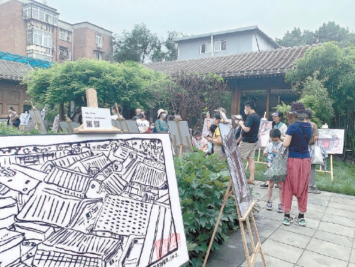 史家衚同流動美術館開幕，展出60多幅速寫作品。圖為社區居民在小院裏參觀畫展。