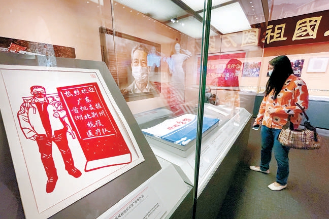 2022年6月14日，觀眾在“人格的力量——中國共産黨人的家國情懷”展上陳列的抗擊疫情相關文藝作品前駐足。 （鄧偉 攝）
