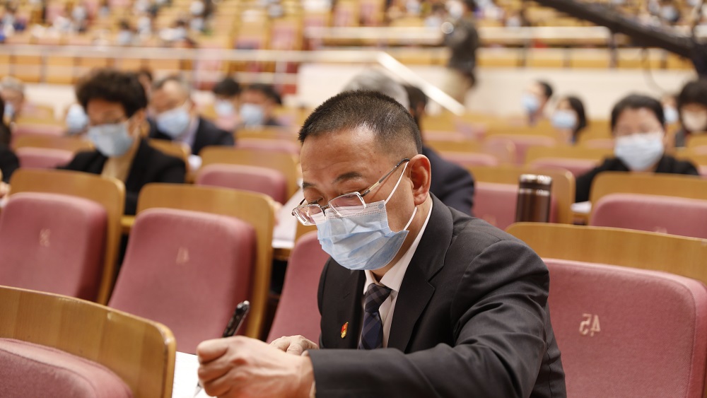 代表們認真聽取市人大常委會工作報告