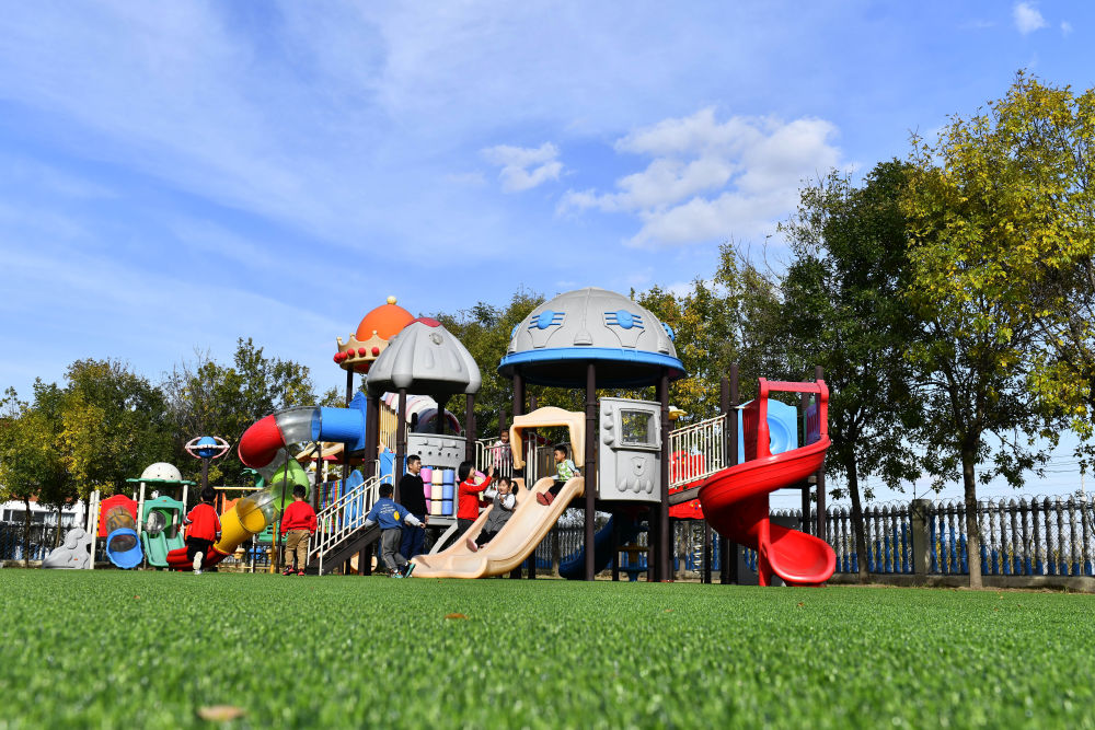 在山東省東營市墾利區楊廟社區幼兒園，孩子們在老師的帶領下進行戶外活動（2021年10月19日攝）。
