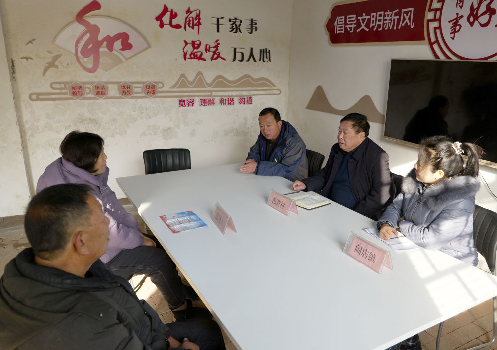 在寶豐縣鬧店鎮范營村“擺理堂”，村鎮幹部（右）為村民進行信訪調解（2023年12月20日攝）。河南省寶豐縣積極推進四走訪基層工作深入開展，已打造鬧店鎮范營村“擺理堂”、石橋鎮東大莊村“老娘舅茶室”等系列鄉村社區服務陣地，協調鄰里關係，有效化解各類矛盾，同時不斷豐富工作內容，拓展服務功能，助力鄉村振興。