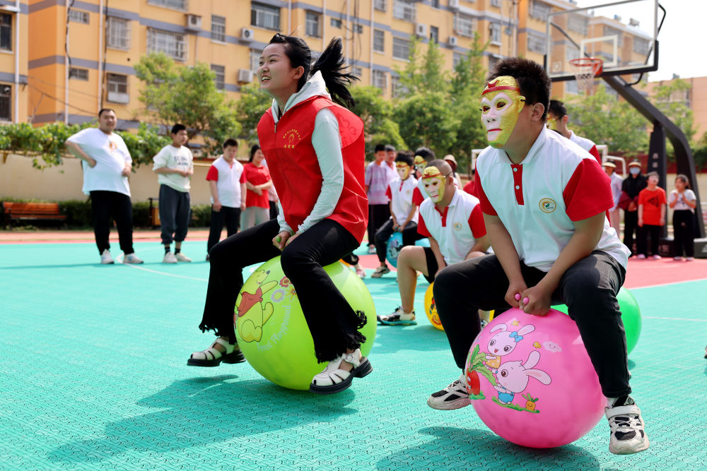2024年5月17日，在山東省棗莊市市中區特殊教育中心，青年志願者與智力障礙學生一起做游戲。