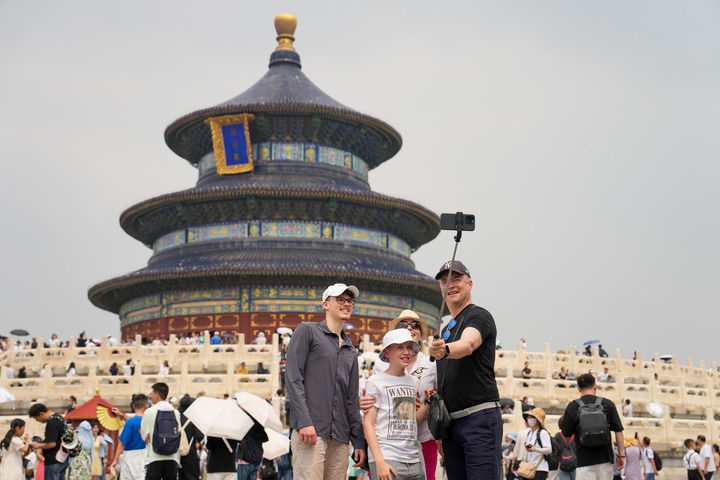 2024年7月9日，來自瑞士的游客在北京天壇公園祈年殿前合影。
