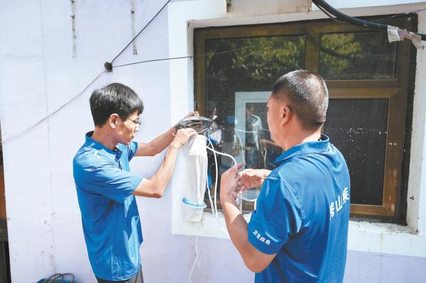 8月23日，在房山區十渡鎮，疾控中心工作人員正在安裝蒼蠅檢測裝置。