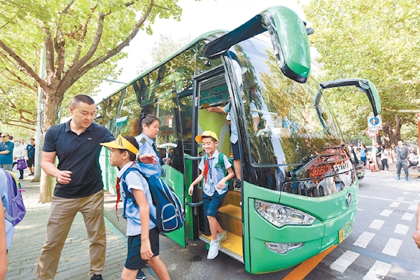 9月1日，北京首批25條通學公交車線路投入試運作。在豐臺一小校門前，首批體驗的小學生乘着綠色的通學公交車來到學校。