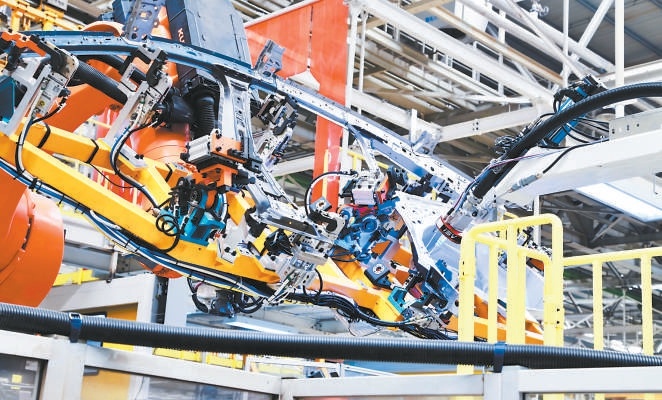 北汽新能源享界超級工廠車身車間內，機器人正對汽車進行焊裝。