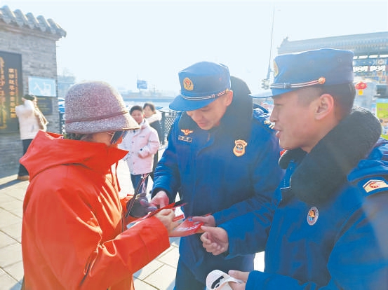 在南鑼鼓巷，消防員巡邏的同時向市民和遊客宣傳消防安全知識。
