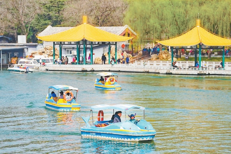 游客在陶然亭公園泛舟。