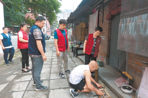 8月4日，石景山區八角街道古城南路社區幹部接到暴雨預警後，迅速組織物業工作人員挨家挨戶詢問房屋有無漏雨情況。