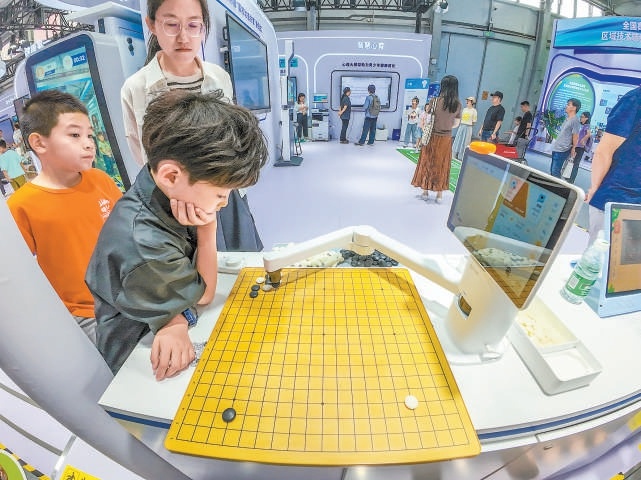 小朋友們在通過智慧機器人學習圍棋。