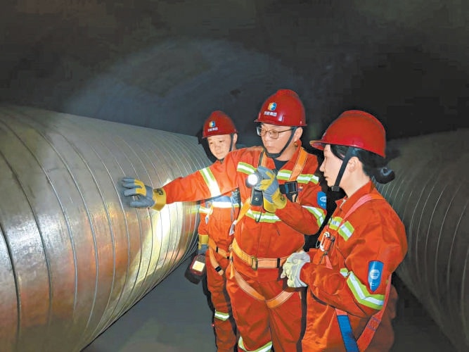 熱力人員下井巡查管網，本報記者張楠（右一）隨同採訪。